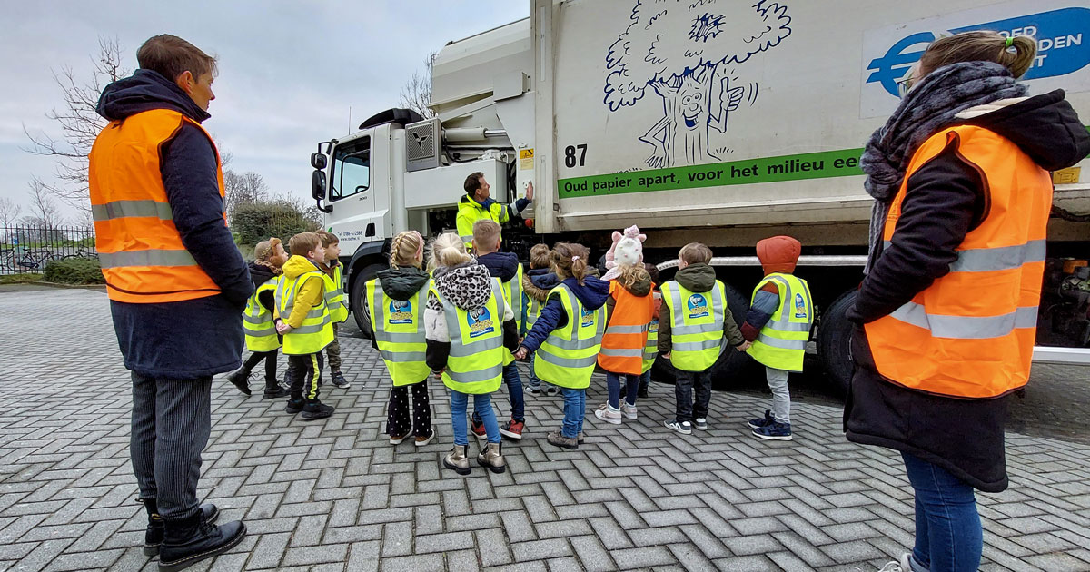 Kleuters en leerkrachtenvan de Sabina van Egmondschool naast een van de RAD-inzamelvoertuigen.