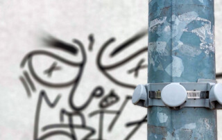 Kroonring aan paal, op de achtergrond graffiti
