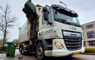 inzamelwagen met zijarm die groene Kliko's (gft-containers) leegt