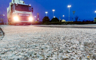 vastgevroren sneeuw op de voorgrond, een van de inzamelwagens van de RAD komt aanrijden