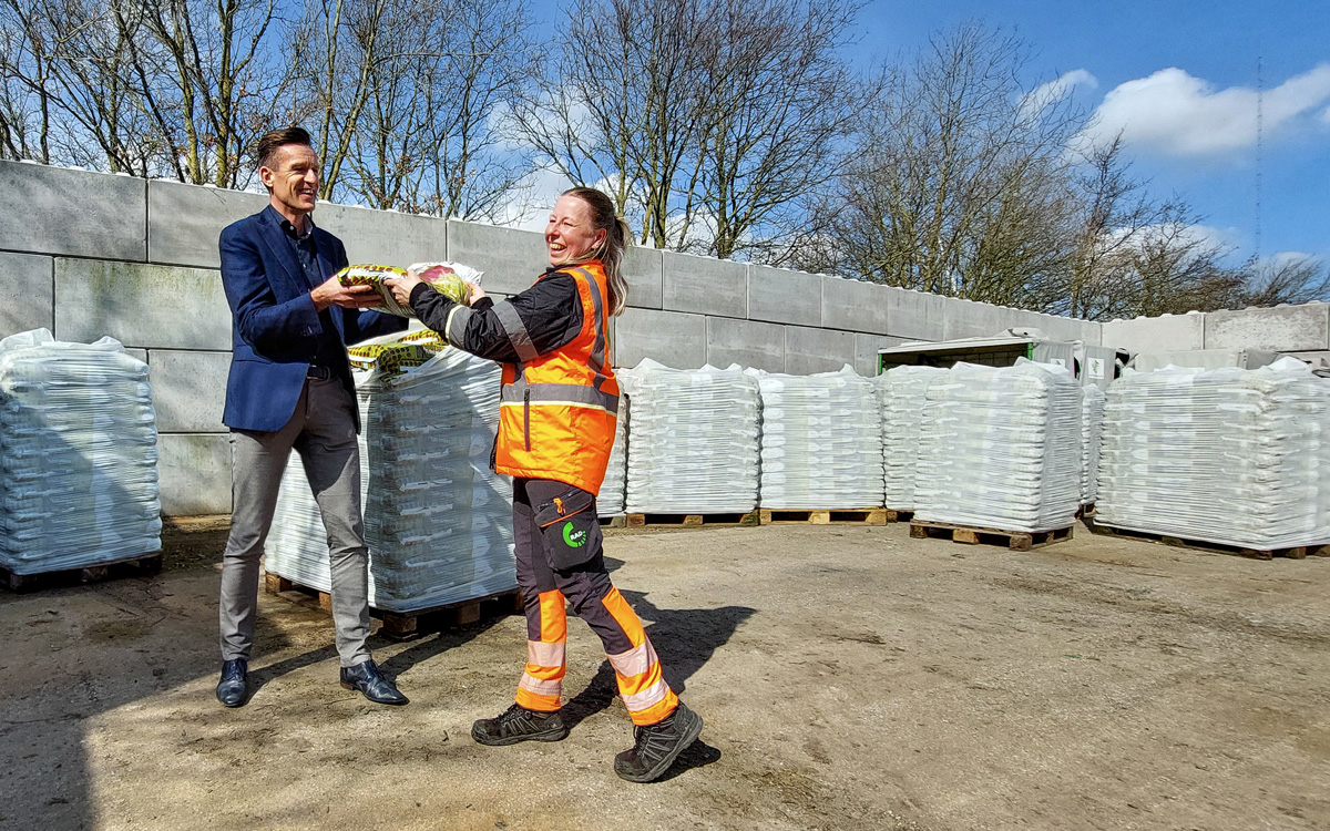 Wethouder Daan Markwat ontvangt een zak compost van voorvrouw milieustraat in Middelharnis