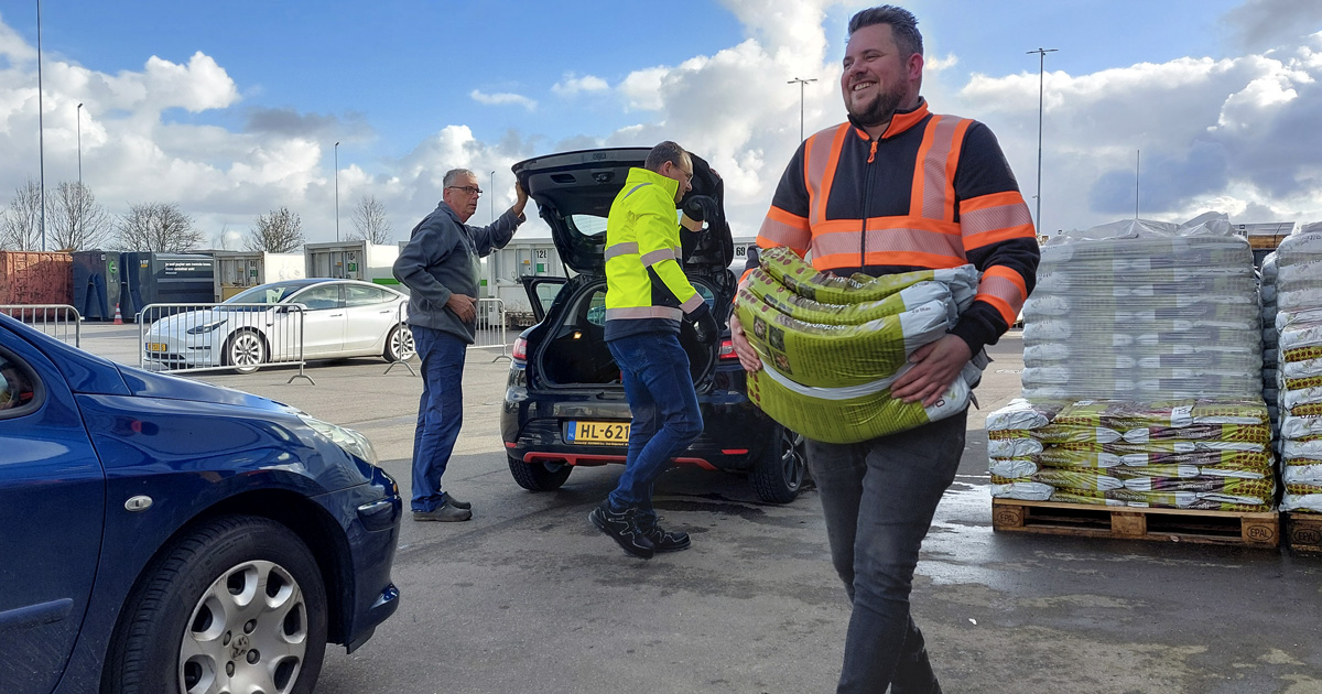 RAD-medewerkers delen zakken compost uit tijdens Landelijke Compostdag in Westmaas