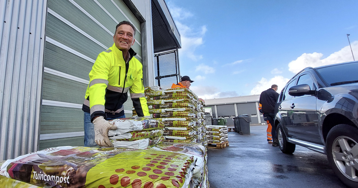 Wethouder Robin Heij helpt met het uitdelen van zakken compost tijdens Landelijke Compostdag bij de RAD in Westmaas