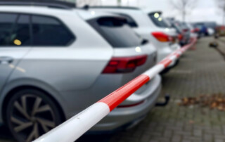 roodwit afzetlint achter geparkeerde foto's