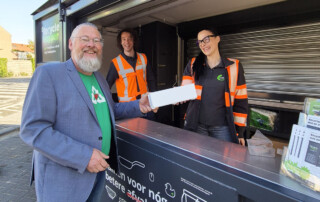 Wethouder Huibert Steen overhandigt recyclebaar afval (piepschuim) aan medewerkers van de RAD in De ReycleHopper in Zuid-Beijerland.