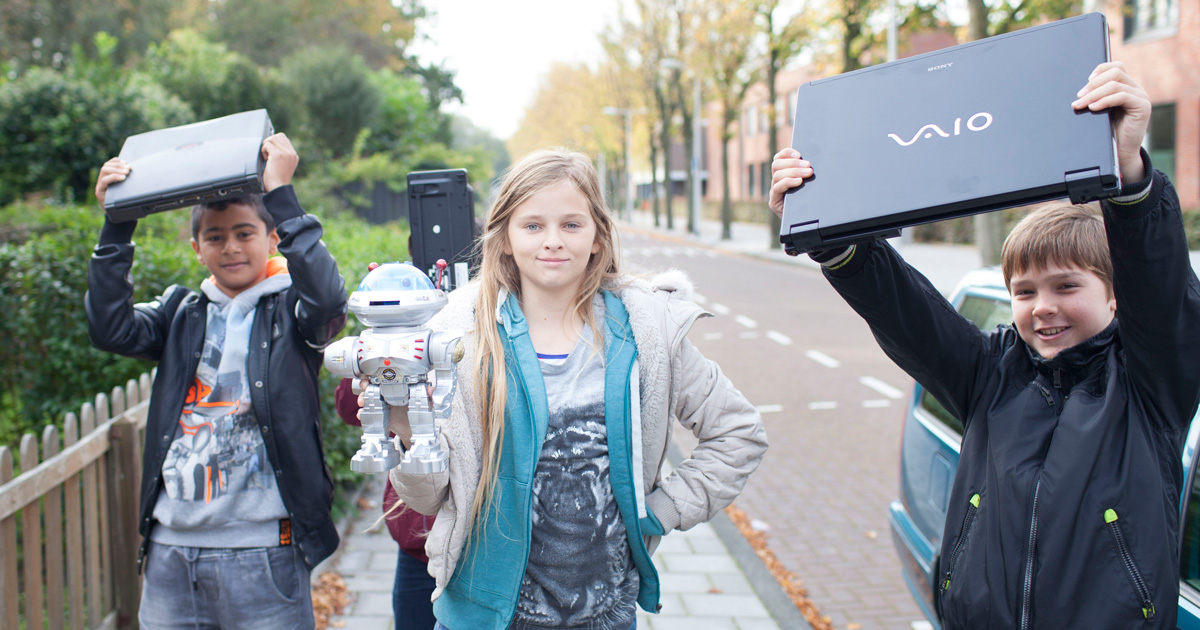 Basisschoolleerlingen met elektrische apparaten tijdens de E-waste Race