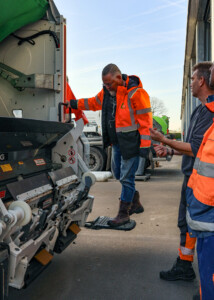 Wethouder Huibert Steen op de treeplank van een van de achterladers van de RAD.